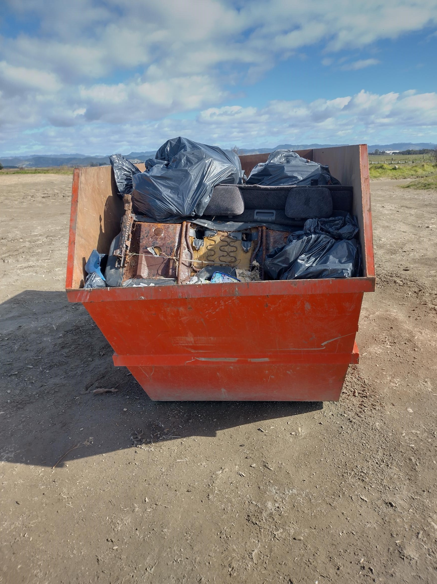 Skip bin full of rubbish 2023 midway beach